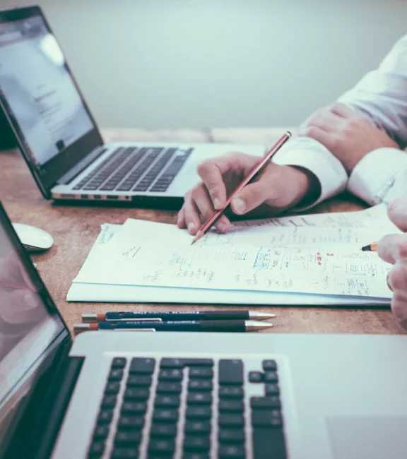 ludzie dyskutujący przed laptopami